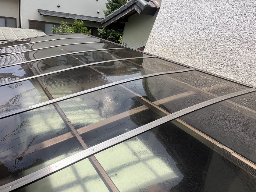 洗浄後のカーポートの屋根。汚れが落ちて下の地面が見えている